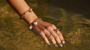 Wasserfeste Armbänder und Ringe aus goldfarbenem Edelstahl im Wasser. Schmuck für Alltag, Strand, Pool und Urlaub.